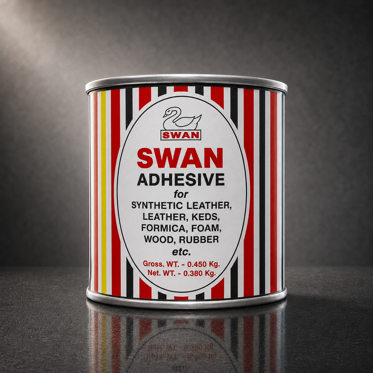 A cylindrical metal can of Swan Adhesive standing upright on a dark reflective surface against a dark gray studio background. The can has a white oval label with red and black text and is surrounded by vertical red, black, white, and thin yellow stripes.